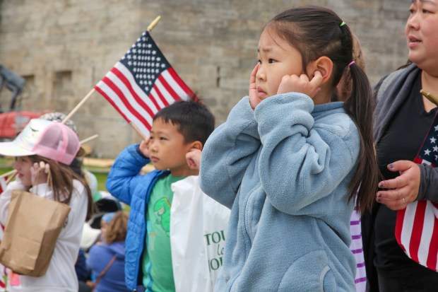 Boston MA - Maddie Wong, 6, covers her ears as the USS Constitution fires a 21 gun salute in honor of women veterans seen from Castle Island June 9, 2023 in Boston Massachusetts. (Photo by Reba Saldanha/Boston Herald)