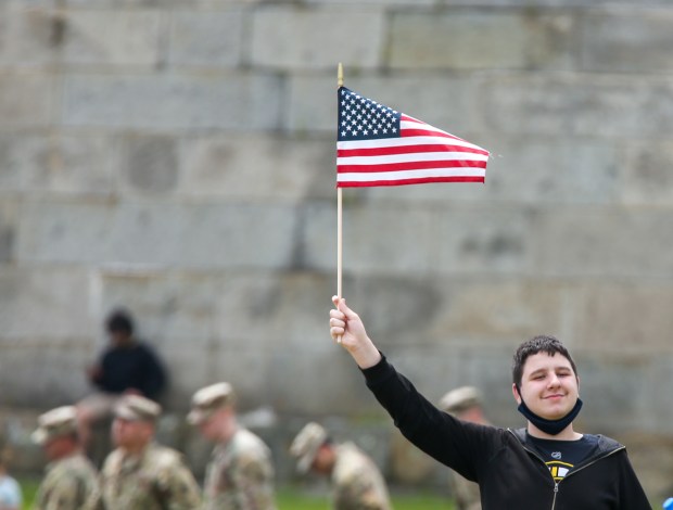 Boston MA - Quincy Public School 8th grader Teddy Tobin holds a flag for a photo after the USS Constitution fires a 21 gun salute in honor of women veterans seen from Castle Island June 9, 2023 in Boston Massachusetts. (Photo by Reba Saldanha/Boston Herald)