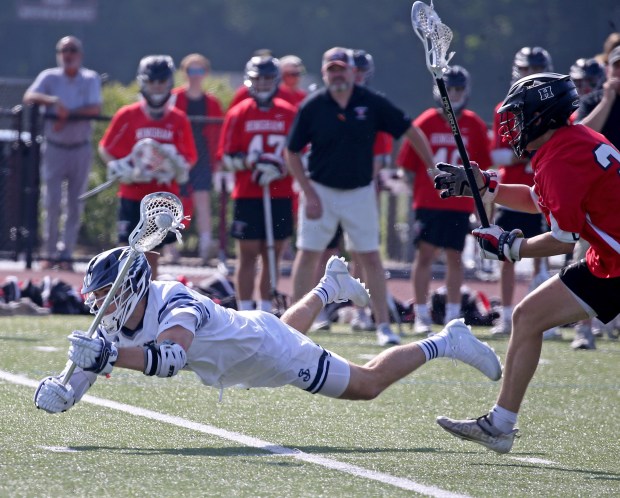 Matthew Morrow of St. John's Prep, left, is knocked to the turf by Hingham's Jack Nicholas during a 14-5 victory by St. John's on Tuesday. (Stuart Cahill/Boston Herald)